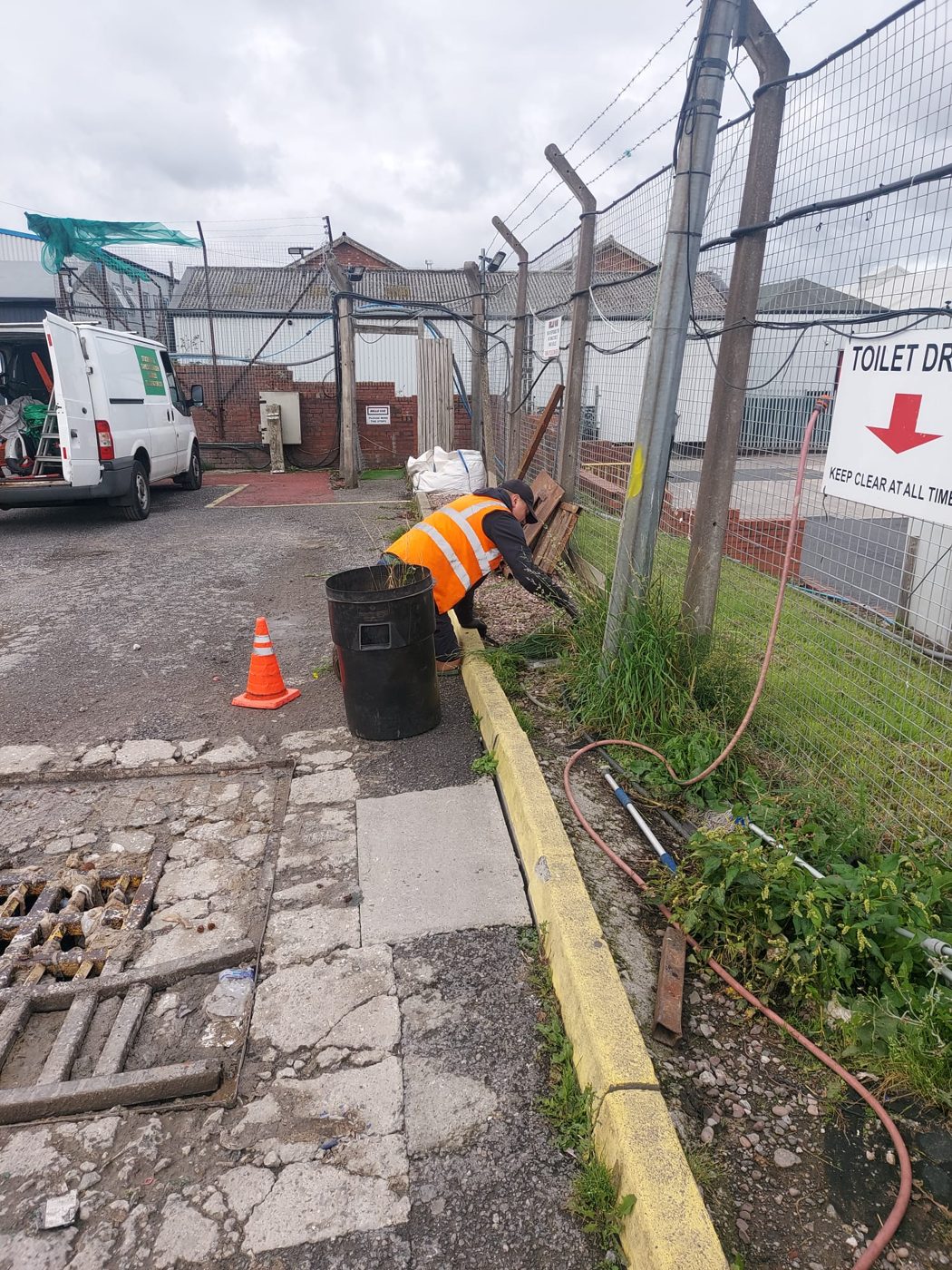Operative removing weeds from a fenced commercial site perimeter